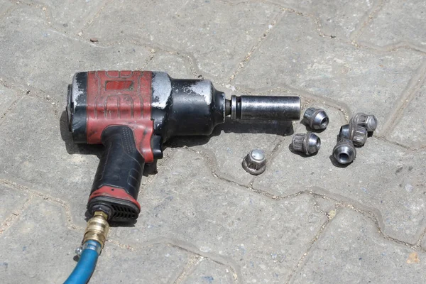 Old impact wrench and nuts. Tire Exchange and repair.