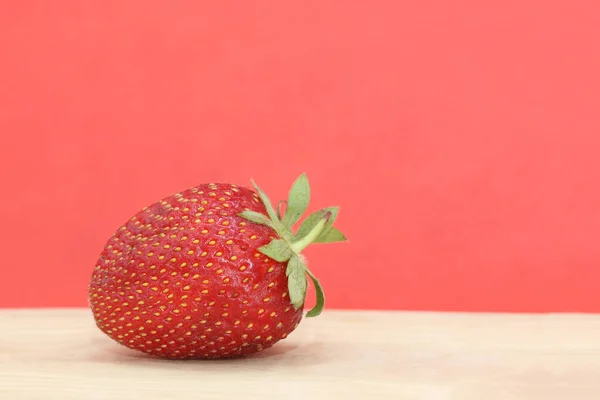 红底木柴上的孤立草莓 — 图库照片