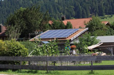 Çatıda güneş panelleri olan özel bir evin çatısındaki paneller yenilenebilir enerji konsepti.