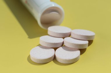 Sarı yüzeydeki B12 vitamini tabletlerini kapat. Eczane konsepti.