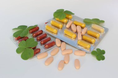 haplar, kapsüller ve yapraklar beyaz arkaplanda