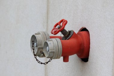 Kırmızı yangın musluğu duvara monte edildi.