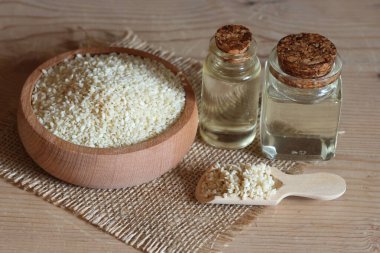 Şişelerde susam yağı ve susam tohumları.