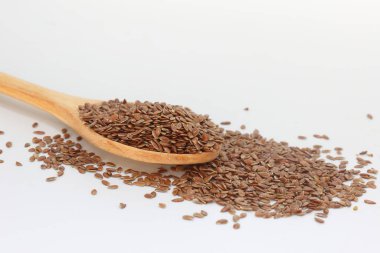 Beyaz arka planda tahta kaşıkta keten tohumları