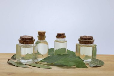 Daphne yaprakları ve temel yağ beyaz arka planda şişelerde