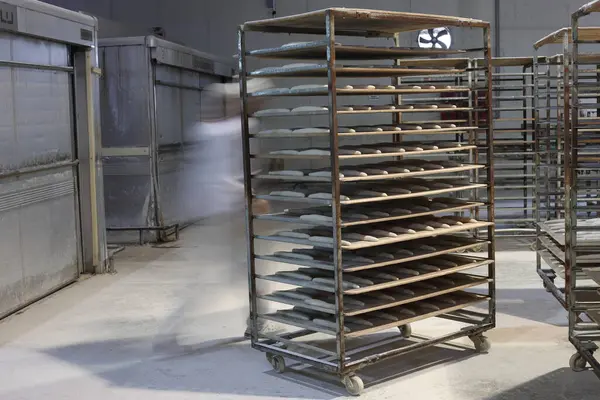 Her biri ekmek hamuru dolu tepsilerle dolu metal bir tramvay.