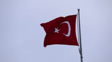 Açık mavi gökyüzüne karşı zarif bir Türk bayrağı dalgalanıyor