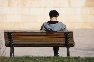 Halka açık bir bankta oturan genç bir adamın dikiz aynası.