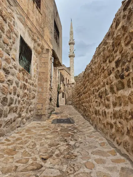 Mardin 'in dar taşlı sokaklarının çerçevelediği bir minare.