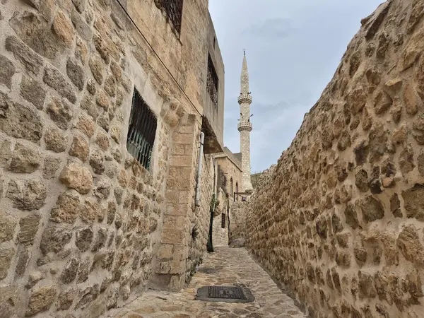 Mardin 'in dar taşlı sokaklarının çerçevelediği bir minare.
