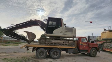 Kazı makinesi inşaat alanındaki kamyonlara yüklendi.