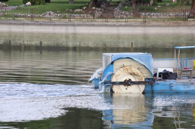 Nehir temizleme teknesi iş başında.