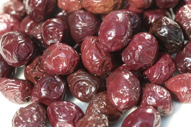 beyaz arkaplanda sunulan ve yağlanmış zeytinler