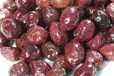 beyaz arkaplanda sunulan ve yağlanmış zeytinler