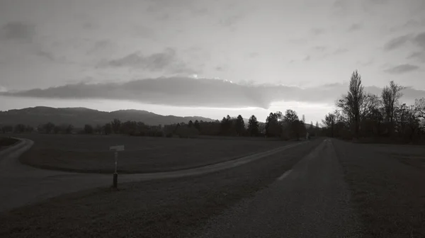 大きな牧草地と標識と日没後の歩道それの横に黒と白で — ストック写真