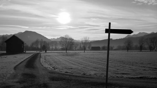 オーストリアの寒い冬の朝の風景の中のパス上の標識黒と白の背景に木々や山と — ストック写真