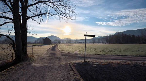 日の出の冬の朝 木の小屋や山を背景に国道沿いの標識 — ストック写真