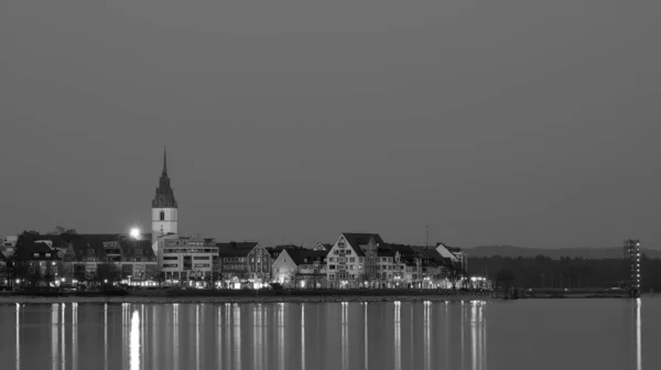 Friedrichshafen Rıhtımı. St. Nicholas Kilisesi ve Köstebek Kulesi manzaralı. Akşamları siyah beyaz.