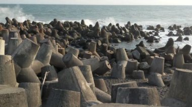 Hint Okyanusu 'nun dalgaları, Glagah Kulon Progo plajında, Yogyakarta' da beton bir dalga kırıcıya çarpar..