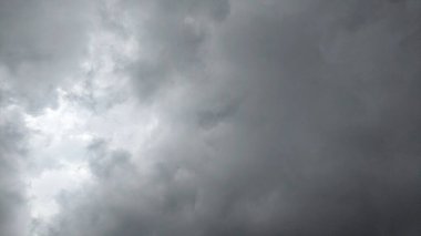 Karanlık, uğursuz bulutları olan bulutlu bir gökyüzü. Bulutlar kalın ve hızlı hareket ediyor gibi görünüyor. Bulutların arasından görünen belli belirsiz ışık çizgileri var..