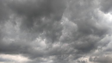 Bulutları delip geçen tek bir güneş ışığıyla dramatik, bulutlu bir gökyüzü. Karanlık, kara kara düşünen bulutlar bir gerilim hissi yaratıyor..