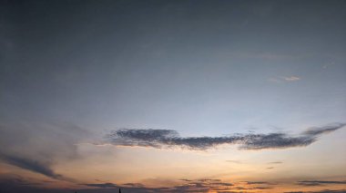 A dramatic sunrise sky with a mix of dark, stormy clouds and a vibrant orange sunrise. The clouds create a sense of depth and movement, while the warm hues of the sunset provide a striking contrast. clipart