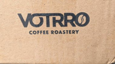 Logo of a coffee roastery called VOTRRO. The logo is printed in black on a brown cardboard surface. clipart