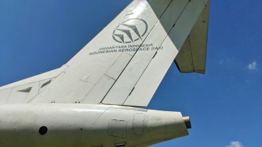 DIRGANTARA INDONEZYA AEROSpace logosu ve metnini açık mavi gökyüzüne karşı gösteren bir uçak kuyruğu yüzgecinin yakın çekimi.