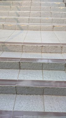 Her basamakta kaygan olmayan şeritler olan gri açık hava merdivenleri güvenli ve dayanıklı bir yol sunuyor..