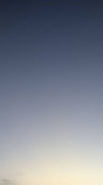 Güzel bir gündoğumu gökyüzü. Tepesi koyu maviden alta doğru soluk sarı ve turuncu renge doğru yumuşak bir eğim. Gökyüzü çoğunlukla açık ve minimalist..