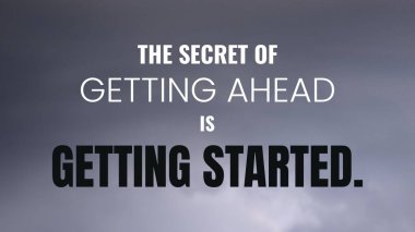 Bulutlu bir gökyüzüne karşı beyaz ve gri bir metinde motive edici bir alıntı. Alıntı şu ki, ilerlemenin sırrı başlamaktır. Metin kalın ve koyu arkaplana karşı duruyor..