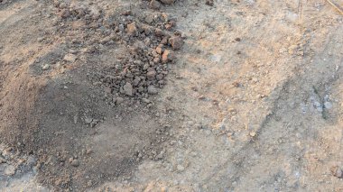 Daha koyu, ince taneli bir toprak parçası daha büyük, parçalanmış toprak yığını daha açık ve tozlu bir yüzeyde yatıyor. Alan, zıt toprak dokusu ve tonlarıyla ilgili bir çalışmadır..