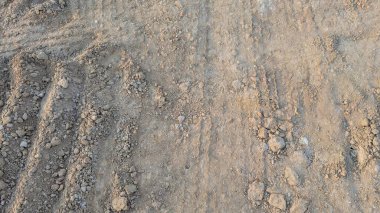 Tozlu, desenli, çapraz taramalı, daha açık renkli toprak ve daha koyu, daha sert toprak kümeleri. İz ve bozulma izleri görülüyor..