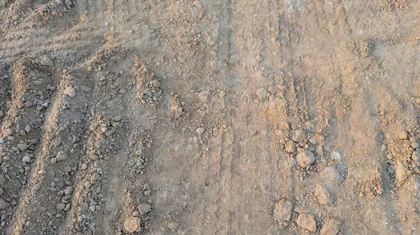 Tozlu, desenli, çapraz taramalı, daha açık renkli toprak ve daha koyu, daha sert toprak kümeleri. İz ve bozulma izleri görülüyor..