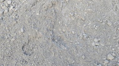 Ayrıntılı, açık gri ince kütle ya da volkanik kumun birleşik dokusu, parçacık boyutu ve küçük kümelerdeki ince varyasyonları gösteriyor. Çiğ ve toprak soyut bir arkaplan.