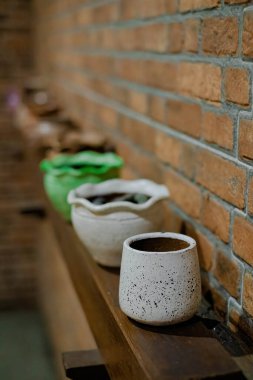 Çamurdan yapılmış kupa ve dekorasyon için beyaza boyanmış arka planı bulanık, alan derinliği dar