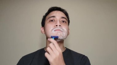 Genç bir Çinli bıyığını ve sakalını kesiyor.