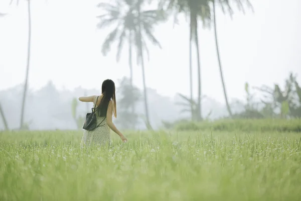 Hi-res photo of an south east asian teenager girl traveling in the middle of rice field with blurred background
