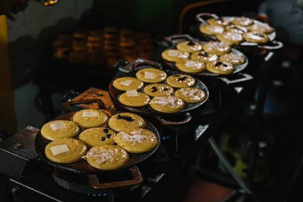 Hindistan cevizi sütü, un, yumurta ve patates Kue Lumpur ya da Mud Cake olarak bilinen geleneksel Endonezya atıştırmalıkları üretmek için kek tepsisinde kızartılır.
