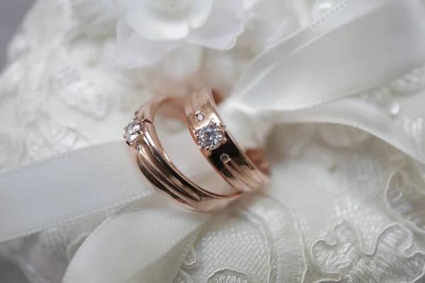 ペアの白い布で結ばれたダイヤモンドとローズゴールドの結婚指輪 — ストック写真
