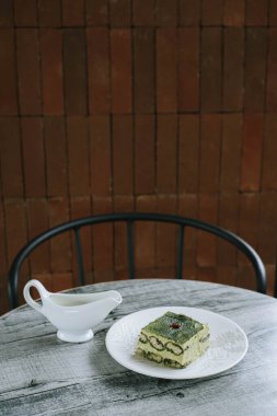 Japon kibrit kekinin portresi ya da dikey çekimi. Tahta masadaki kremalı sürahi ile.