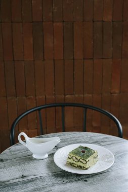 Japon kibrit kekinin portresi ya da dikey çekimi. Tahta masadaki kremalı sürahi ile.