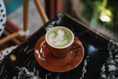 Siyah mermer bir masada Latte Art ile bir fincan Matcha Latte. Bulanık arkaplan.
