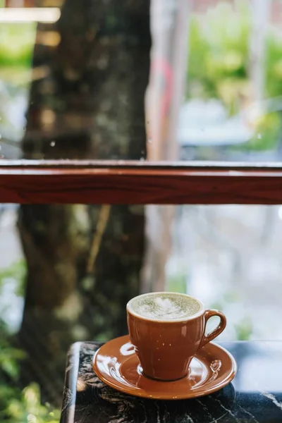 Pencerenin Yanındaki Siyah Mermer Masada Bir Fincan Matcha Latte Latte — Stok fotoğraf
