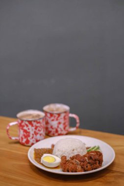 Nasi Lemak 'ın iki bardak çayla portresi ya da dikey görüntüsü. Bulanık arkaplan.