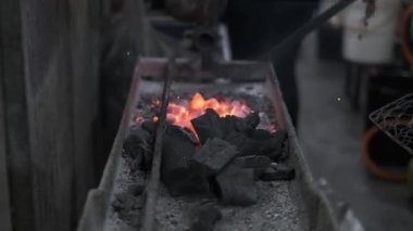 Bir el adam ızgara balık yapmak için kömür yakıyor.