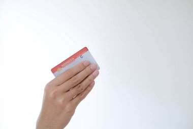 Surat Ijin Mengemudi veya SIM C, izole edilmiş beyaz arka planda bir el tarafından tutulan bir motosiklet için Endonezya ehliyeti anlamına gelir