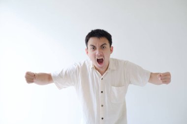 Bej gömlek giyen genç bir Asyalı ve sol bileğinde bir akıllı yama kızgın bir ifadeyle kameraya bakıyor. İzole edilmiş beyaz arka plan. Reklam için uygun..