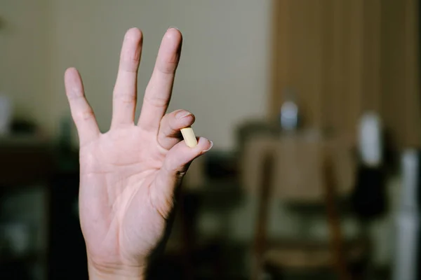 Ett Gult Piller Hålls Genom Att Peka Och Tumme Finger — Stockfoto