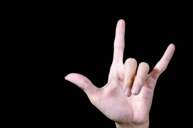 Bir el metal bir jest yapıyor. İzole edilmiş siyah arkaplan.